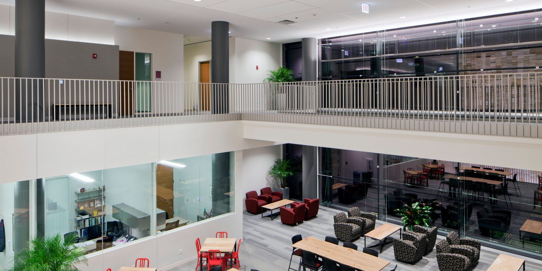 高等教育建設 - バカラ 初心者 シュライバー センター クインラン ビジネス スクール、テーブルのある 2 階建てのオープン アトリウム通路